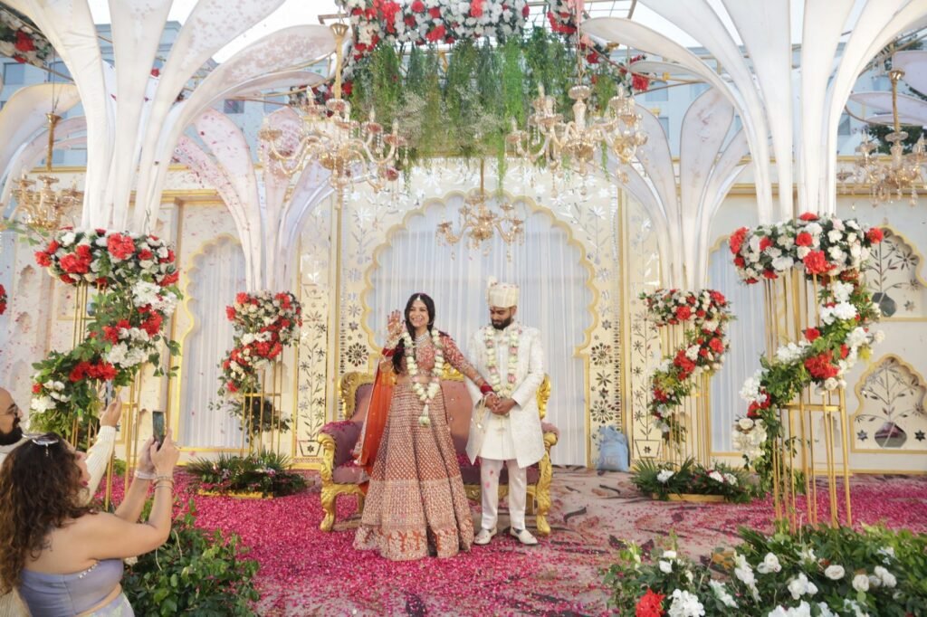 Couple seated on a floral mandap stage