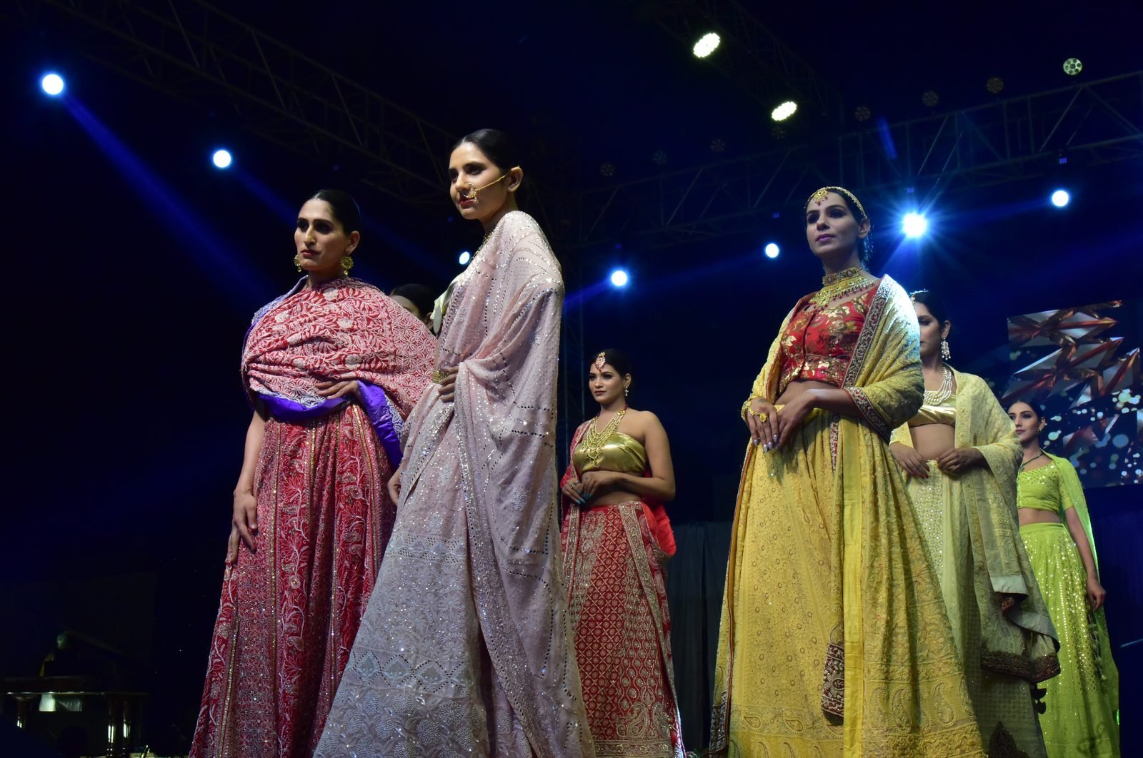 Models in lehengas on a runway at a fashion show