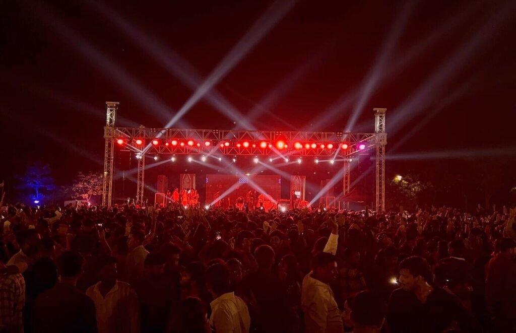 Concert stage with red beam lighting and crowd in Lucknow